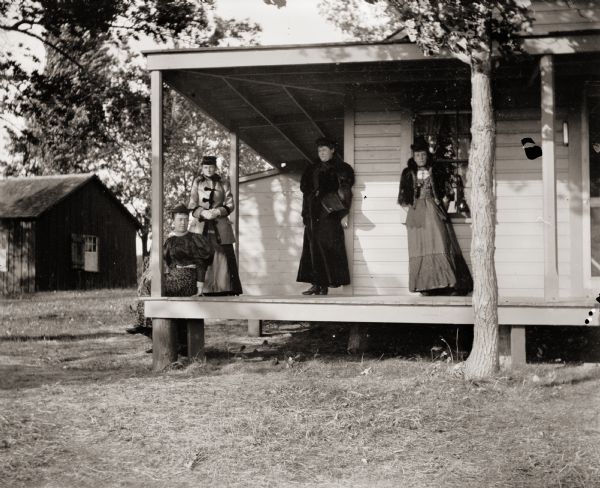 Group of four women on the front porch of Somm's cottage.
