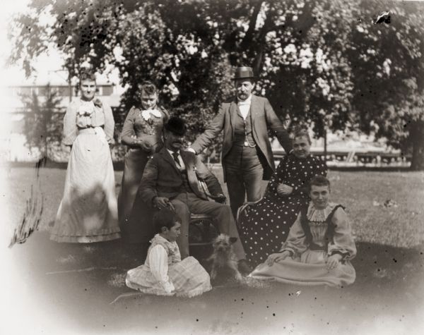 Man, identified as Stevens, and his family posing outdoors.