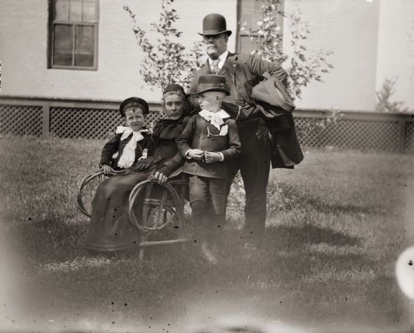 Charles Matt and his family posing around Mrs. Matt's chair.