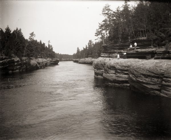 Group of four standing on the rocks along shore of the Wisconsin River at the Wisconsin Dells.