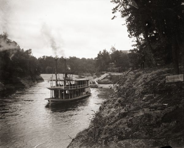 View from elevated rocks on shoreline of a steamboat on the Wisconsin River touring the Wisconsin Dells.