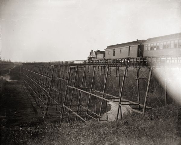 Wisconsin Central train passing over the White River bridge. The first railroad car is imprinted with "U.S. Mail."