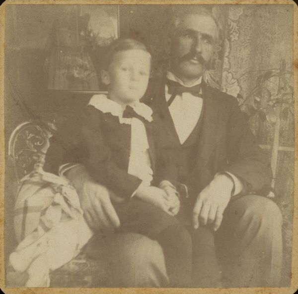 Dr. Edward A. Bass holds his son, Edward Cary Bass, on his lap in the parlor of their home.