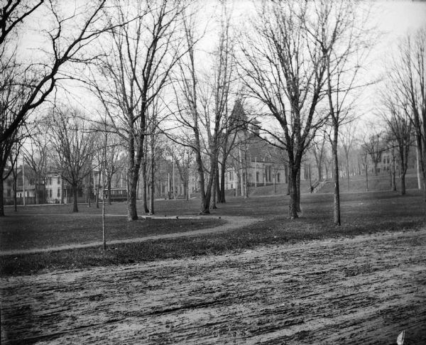 A view of the University of Wisconsin-Madison campus including Music Hall and the bottom of Bascom Hill. Langdon Street is in the foreground; a streetcar is seen on State Street near its intersection with Park Street.  The Wisconsin Historical Society Library and Archives Building now stands on this site.