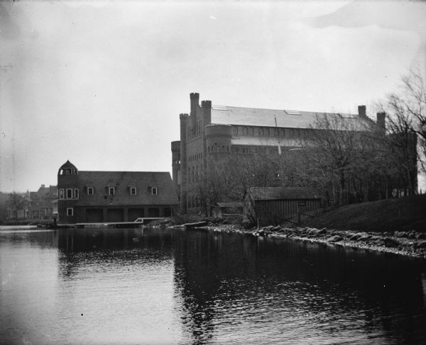Exterior view from Lake Mendota of the boathouse on shoreline on the University of Wisconsin-Madison campus. Behind the boathouse is the Armory (Red Gym or Old Red).