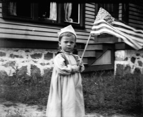 The photographer's son Cary waves an American flag in front of their home in Montello, now 131 East Montello Street.