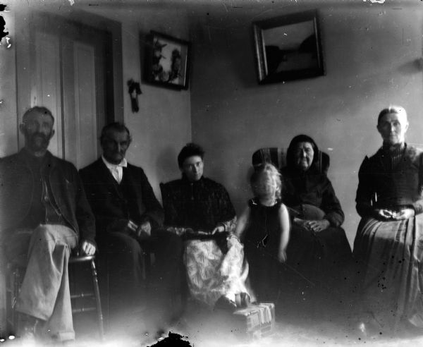 Ada Burlingame Bass, center, with her daughter Everetta, and parents Leroy J. (far left) and Alvina Burlingame (far right.)  The other man and woman are unidentified. An ornament in a shadow box hangs on the wall behind the group.