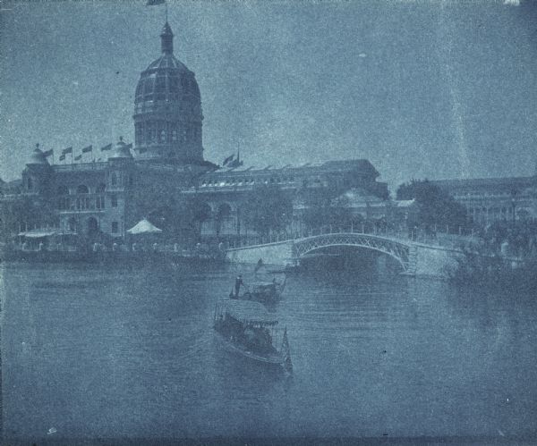 Cyanotype view of the Illinois Building at Chicago's World's Columbian Exposition showing a gondola and motor launch on the lagoon near a bridge. A wing of the Palace of Fine Arts, now the Museum of Science and Industry, is visible in the background.