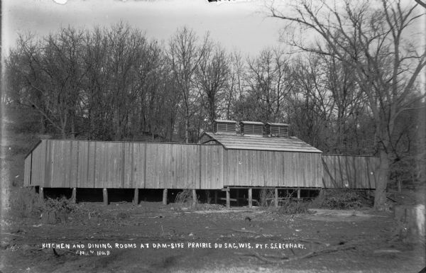 Newly construced kitchen and dining rooms at the construction camp for the dam on the Wisconsin River. The kitchen building has three ventilators on the roof.