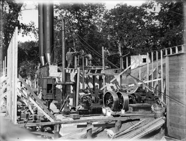 Workmen pose during construction of the temporary steam power plant at the Prairie du Sac dam.  These engines provided electric power for the construction of the dam.