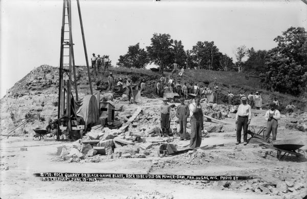 Workmen and machinery at the quarry on Blackhawk Bluff. The gravel was used in construction of the power dam.