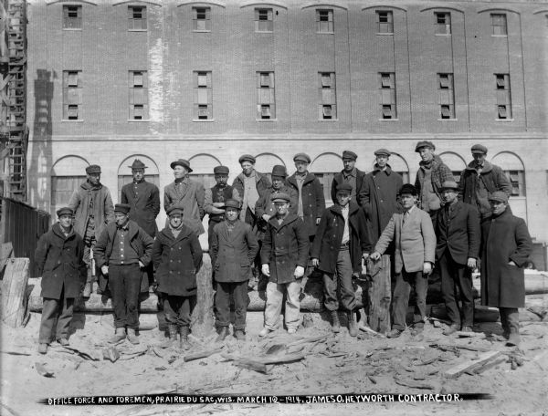 Office force and foremen posing in front of the south side of the power house at the Prairie du Sac dam.