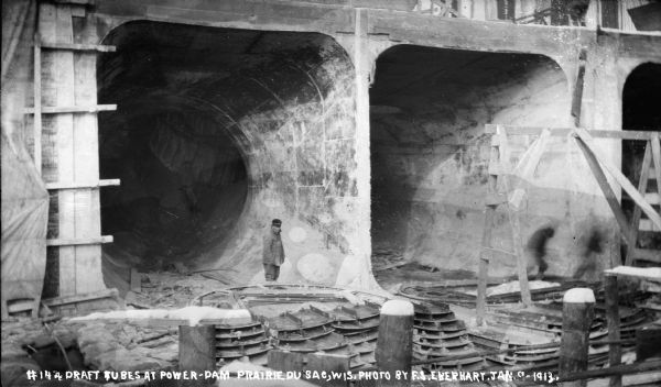 Men are standing in the completed draft tubes after removal of the steel forms.