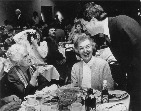 Al Gore talking to two women at a dinner.