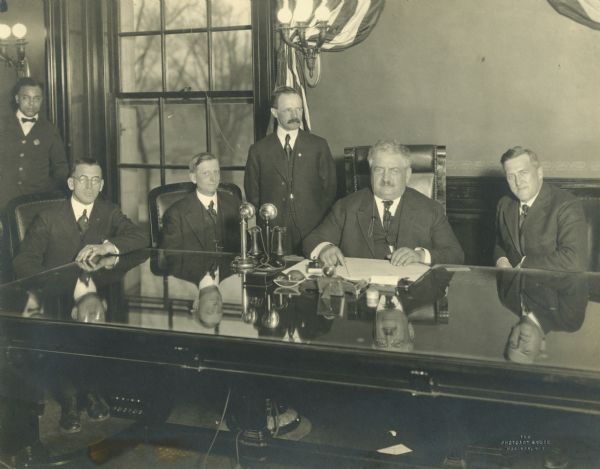 Governor Emmanuel Philipp ratifying the 18th Amendment which made Prohibition law. From left to right: Executive Messenger, Samuel Banks; Senator George B. Skogmo; Secretary. L.C. Whittet; Secretary of State, Merlin Hull; Governor E.L. Philipp; and Lieutenant Governor, E.F. Dithmar.