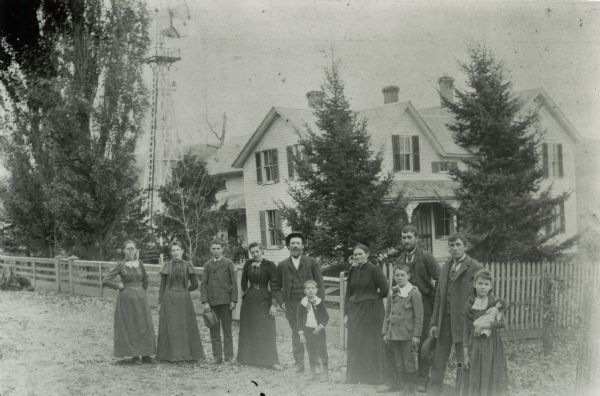 Group portrait of the Jacob Gasser family standing in front of the farmhouse at Tower Rock Farm.