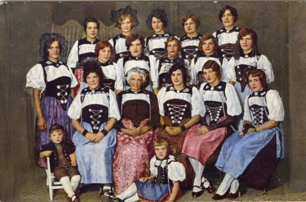 Hand-colored studio portrait of women and children in Swiss costume.