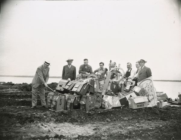 Destroying slot machines and other illegal gambling devices at Law Park. From L to R: John Roach, director of the state beverage and cigaret tax division; John R. Arnold, former sheriff of Dane County and deputy U.S. Marshal; Sam Swenson, Harold Schaurer, L.D. Lewis and J.G. McClellan, investigators with the state beverage and cigaret tax division and F.J. Mattingly, senior investigator.