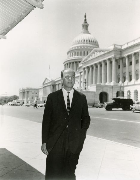 U.S. Senator and former Wisconsin Governor, Gaylord Nelson, standing on a sidewalk with the United States Capitol building in the background.