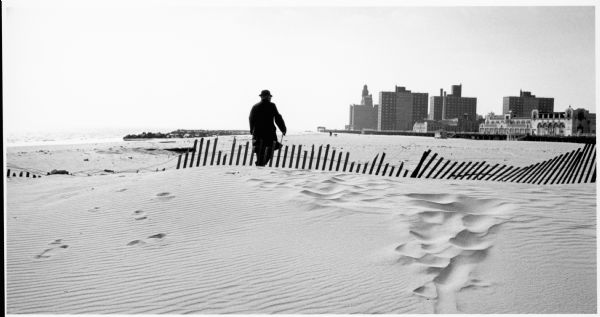 Man walking on Coney Island Beach.