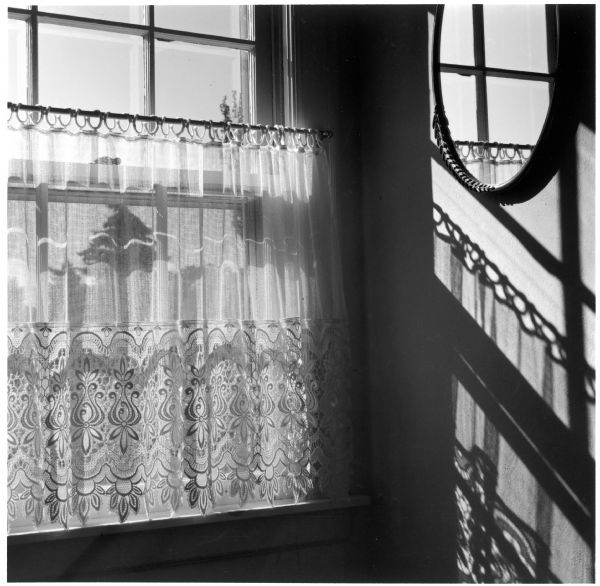 Lace curtain of the upstairs window in the Quinney house at 345 Rolfe Road.