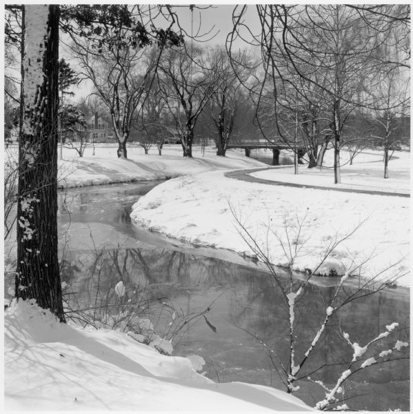The Kishwaukee River in winter and its snow-covered banks.