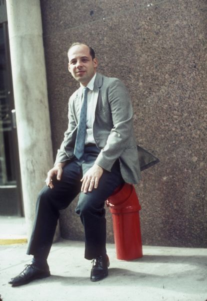 A business man sits on a water pipe while smoking outside of a building near the construction site of the World Trade Center.