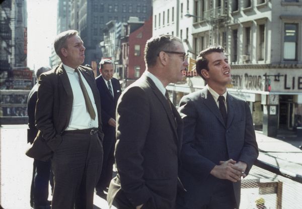 Several businessmen converse with each other while observing the World Trade Center construction.