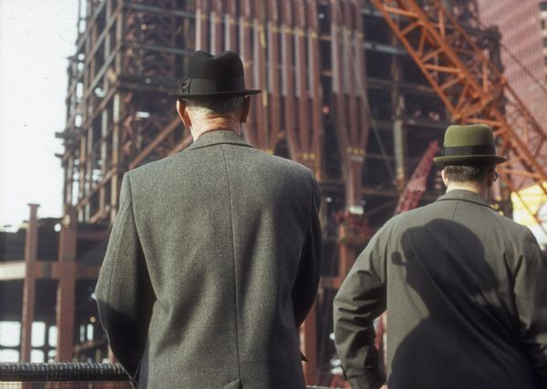 View from the back of two men watching the construction of the World Trade Center.