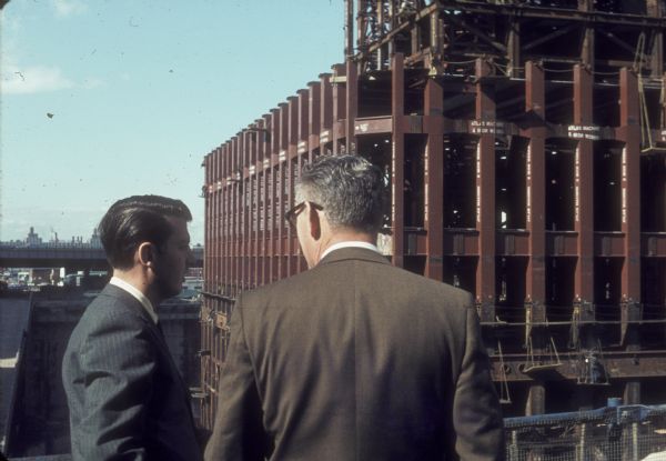 Two businessmen watching the construction of the World Trade Center Tower.