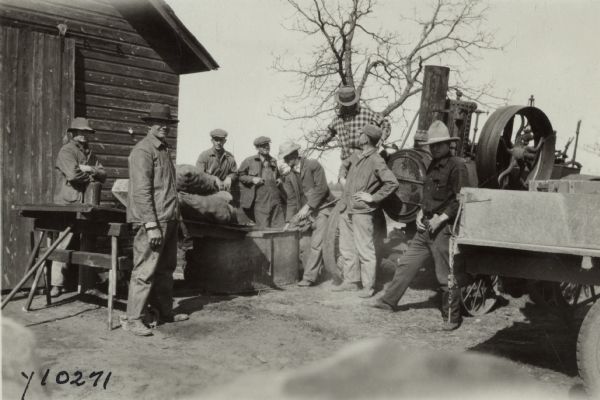 Agricultural extension demonstration on the William Wegert farm near Friendship. A group of farmers are watching a hot formaldehyde treatment on potatoes for the prevention of diseased tubers. The steam was supplied by a nearby traction engine.
