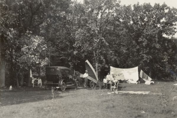 Camping scene along an unidentified Wisconsin road. Although part of the Wisconsin Good Roads collection of Melvin Diemer, this photograph was probably taken by Hotchkiss as part of that early 1920s assignment. Someone has captioned the photograph: "Thousands of tourists are met camped by the roads."