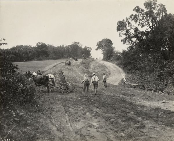 Road construction just north of the Crawford-Vernon County line on State Highway 27, showing both the new and old routes.  According to the caption on the photograph this small relocation job was done with "wheelers."  The photograph was taken for the Wisconsin Good Roads Association during the early 1920s.