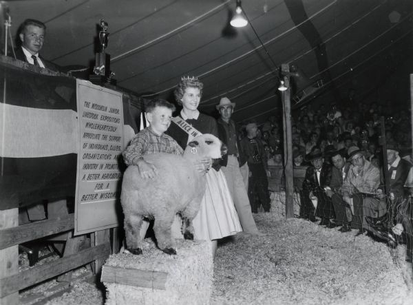 Alice in Dairyland, Joan Engh, posing with a young winner in the lamb and sheep competition at a junior livestock exposition. Joan went on to become Miss Wisconsin in 1962, and was first runner-up in the national Miss America contest.