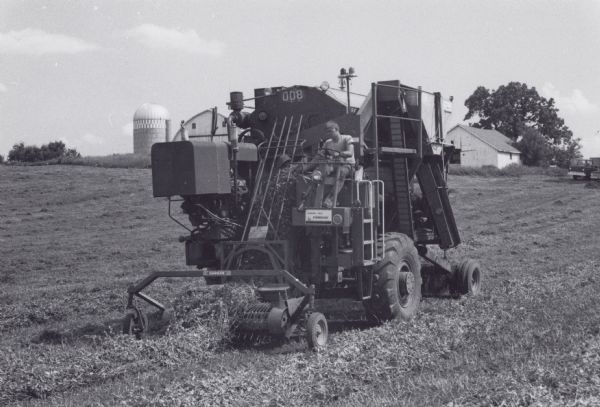 A pea combine in use on an unidentified Wisconsin farm.