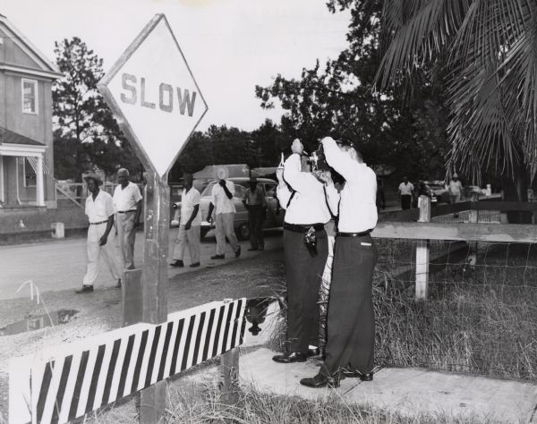 Private security guards hired by the Colonial Sugar Company photograph striking members of the United Packinghouse Union.  As the result of a court restraining order the strikers were "walking" along a public street. This picture is important because United Packinghouse was one of the few unions that attempted to organize Southern Blacks.