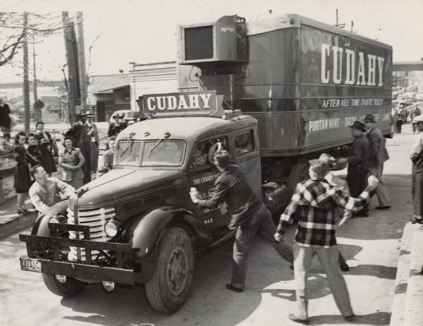 As an empty truck is entering the Cudahy Packing Company plant in Kansas City, Kansas, striking United Packinghouse employees threaten the drivers by appearing to throw rocks. Several strikers had previously been arrested for throwing stones.