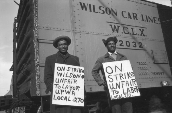 Striking members of United Packinghouse Workers Local 270 stand near the Swift & Co., plant in membership in an attempt to prevent Wilson products being loaded on a train.
