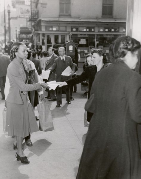 On a Baltimore street corner, Howard Burmeister and Margaret Boyd of United Packinghouse Workers Local 392, distributes a leaflet on the plight of striking sugar workers.