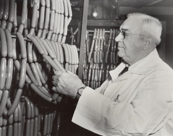 Quality control expert William E. Zimmanck, who began working for Oscar Mayer at age thirteen, inspecting a string of hot dogs.