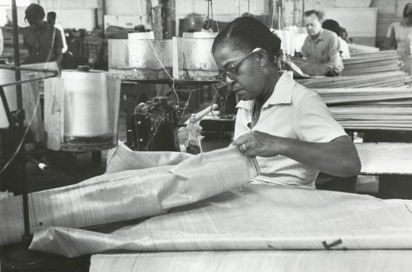 An employee of the Chase Bag company, who was also a member of the Amagalamted Meatcutters and Butcherworkers of North America, stitches at a sewing machine.