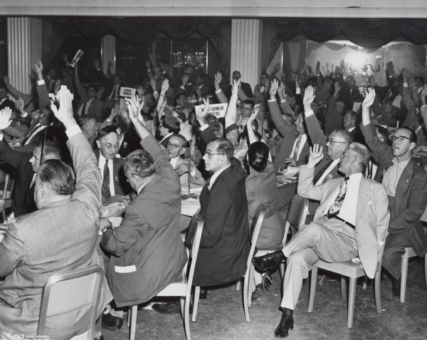 Raising their right hands, an unidentified group of union members voting at the American Federation of Labor (AFL) convention.