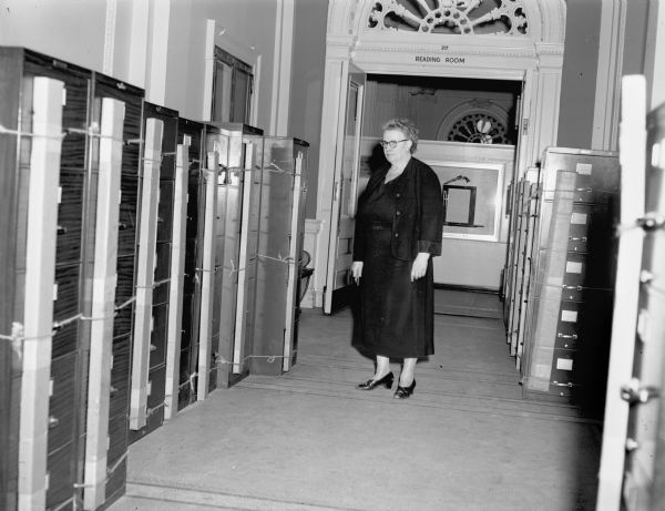 Lucille Kellar, coordinator of the Historical Society's McCormick Collection, with the new cases for the collection. She is standing outside the north entrance to the Library and some exhibit cases can be seen behind her.