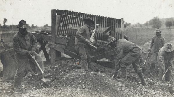Gravel screening and separating plant of the 310th Engineers in operation on a road near Camp Custer. All of the soldiers at work on this road construction drill are African Americans.
