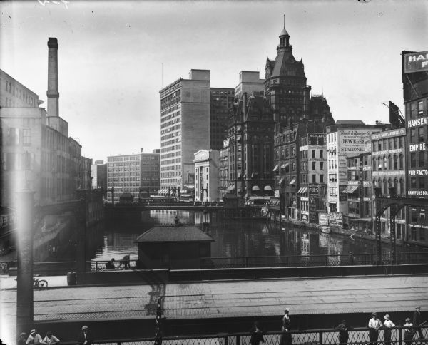 Elevated view of the Milwaukee commercial district looking north over the Milwaukee River from the Michigan Street bridge. Landmarks right to left: Pabst Building, Marshall & Ilsley Bank (smaller white), First National Bank (which was later renamed First Wisconsin), and the Manufacturers Home Building.