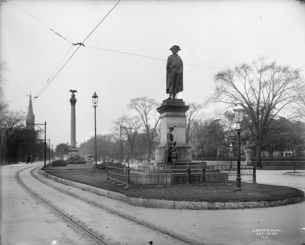 Court of Honor, W. Wisconsin Avenue, looking west from N. 9th Street. The Midsummer Festival monument (with eagle) and Gesu Church steeples are on the left.