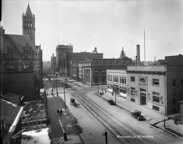 East Wisconsin Avenue commercial district looking west from V. Van Buren Street. Landmarks left to right: Federal Building, Northwestern National Insurance (with gables), Wisconsin Gas Light Co. on extreme right. Caption on glass plate reads: "Wisconsin St. west from Van Buren".