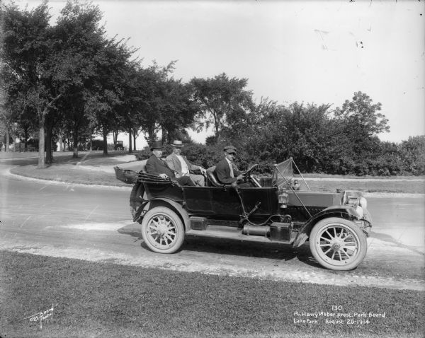 Henry Weber, the president of the Park Board rides in an automobile in Lake Park. Caption on glass plate reads: "Mr. Henry Webster [<i>sic</i>], prest. Park Board".