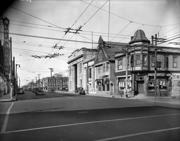 Commercial district and automobiles on W. North Avenue at about N. 34th Street, looking east, with the First National Bank and Bloch Daneman buildings.