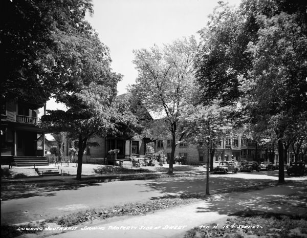 Tree-shaded residential neighborhood at 920 N. 16th at State Street. Caption on glass plate reads: "Looking southeast showing property side of street, 920 N 16th Street".